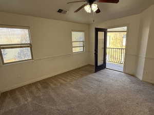 Empty room featuring ceiling fan and carpet flooring