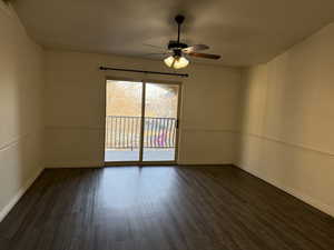 Empty room featuring ceiling fan and dark wood-type flooring