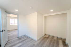 Interior space featuring light wood-type flooring and a textured ceiling