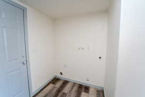 Laundry room with electric dryer hookup and dark hardwood / wood-style floors