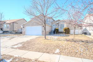 View of front of home featuring central air condition unit and a garage