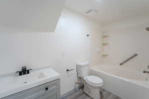 Full bathroom with vanity, hardwood / wood-style flooring, bathing tub / shower combination, and toilet