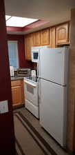 Kitchen with white appliances and light brown cabinets