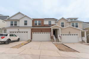 Townhome / multi-family property featuring board and batten siding, concrete driveway, and an attached garage