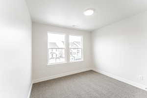 Empty room with visible vents, carpet floors, and baseboards