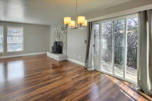 Unfurnished living room featuring dark hardwood / wood-style floors and a notable chandelier