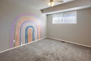 Carpeted spare room featuring ceiling fan