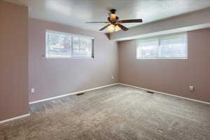 Carpeted spare room with ceiling fan