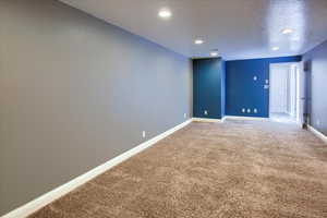 Carpeted empty room with a textured ceiling