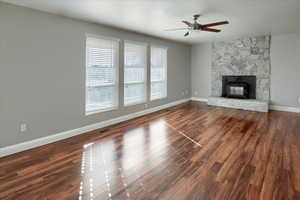 Unfurnished living room featuring dark wood-type flooring and ceiling fan