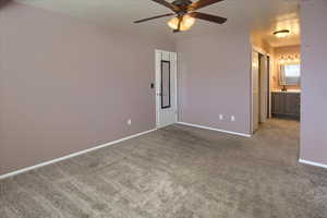 Carpeted empty room with ceiling fan