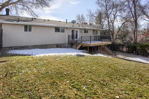 Back of property featuring a deck and a yard