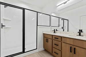 Bathroom featuring vanity and a shower with door