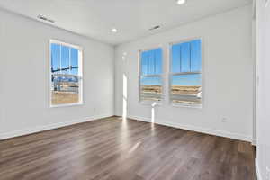 Unfurnished room with hardwood / wood-style floors and a textured ceiling