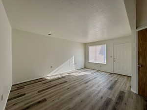 Spare room featuring wood-type flooring and a textured ceiling