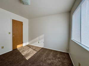 Empty room with plenty of natural light and carpet