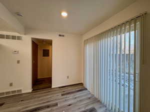 Unfurnished room featuring hardwood / wood-style flooring and electric panel