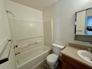 Full bathroom featuring vanity, bathing tub / shower combination, hardwood / wood-style floors, and toilet