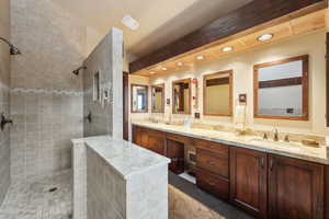 Bathroom with vanity and tiled shower