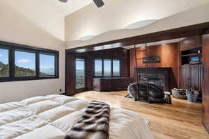 Bedroom with access to exterior, ceiling fan, a high ceiling, and light wood-type flooring