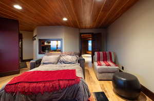 Bedroom with light hardwood / wood-style flooring and wood ceiling