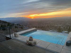 Pool at dusk with a deck with mountain view