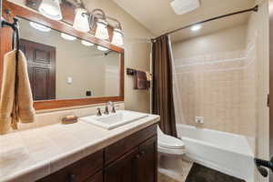 Full bathroom with vanity, shower / tub combo with curtain, and toilet