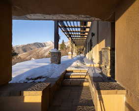 Snow covered patio with a mountain view