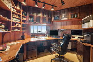 Tiled office with wooden walls, built in desk, and wood ceiling