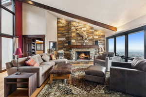 Living room featuring beamed ceiling, a fireplace, and high vaulted ceiling