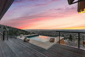 Pool at dusk featuring a wooden deck