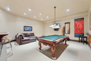 Recreation room with light carpet and pool table