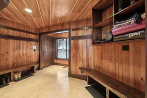 Mudroom with wooden ceiling and wood walls