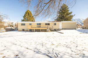 Snow covered property with a deck with mountain view