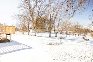 Yard covered in snow featuring a wooden deck