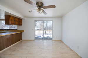 Kitchen with light hardwood / wood-style flooring and ceiling fan