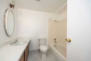 Full bathroom featuring toilet, vanity, and tiled shower / bath