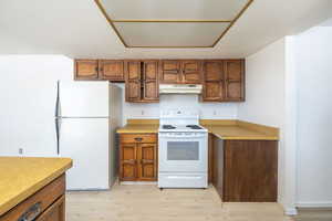 Kitchen with white appliances and light hardwood / wood-style flooring