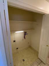 Laundry area with washer hookup, light tile patterned floors, electric dryer hookup, and hookup for a gas dryer