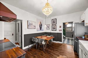 Dining space featuring an inviting chandelier and dark hardwood / wood-style flooring