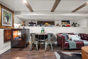 Bar with dark hardwood / wood-style floors and beamed ceiling