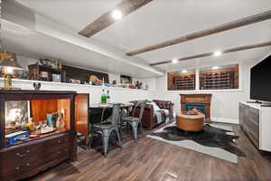 Office area with dark hardwood / wood-style floors and beamed ceiling