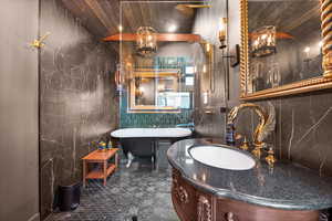 Bathroom with vanity, wood ceiling, and a bathing tub