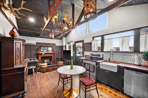 Kitchen with high vaulted ceiling, wood ceiling, sink, and stainless steel appliances