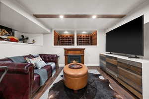 Living room featuring dark wood-type flooring and beam ceiling