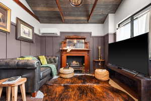 Living room with wood ceiling, hardwood / wood-style floors, and a wall mounted air conditioner