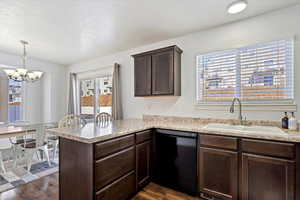 Kitchen with pendant lighting, dishwasher, sink, dark hardwood / wood-style floors, and kitchen peninsula