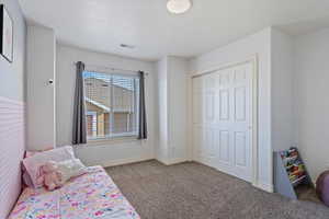 Carpeted bedroom featuring a closet