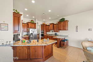 Kitchen featuring a kitchen bar, appliances with stainless steel finishes, and kitchen peninsula