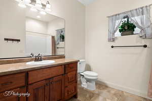 Bathroom featuring toilet, walk in shower, and vanity